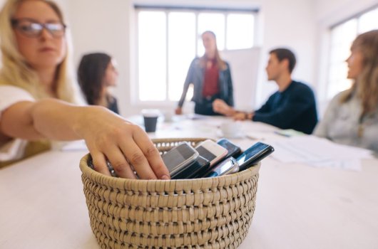 Woman putting her phone away into a basket 