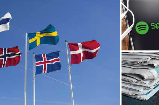 Nordic flags, mobile phone with Spotify's logo and a pile of newspapers. 