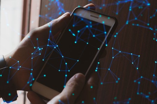 Man holding smartphone, blue network dots connecting. 