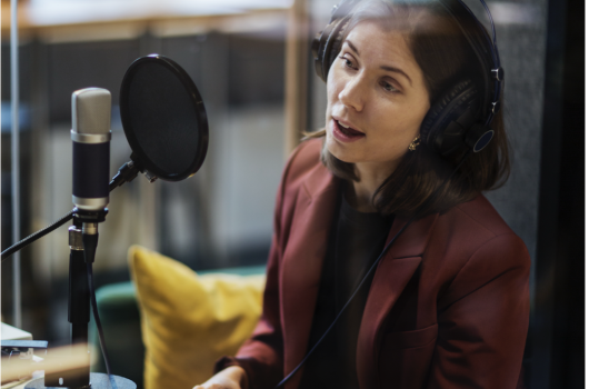Woman speaking in a mic in a studio 